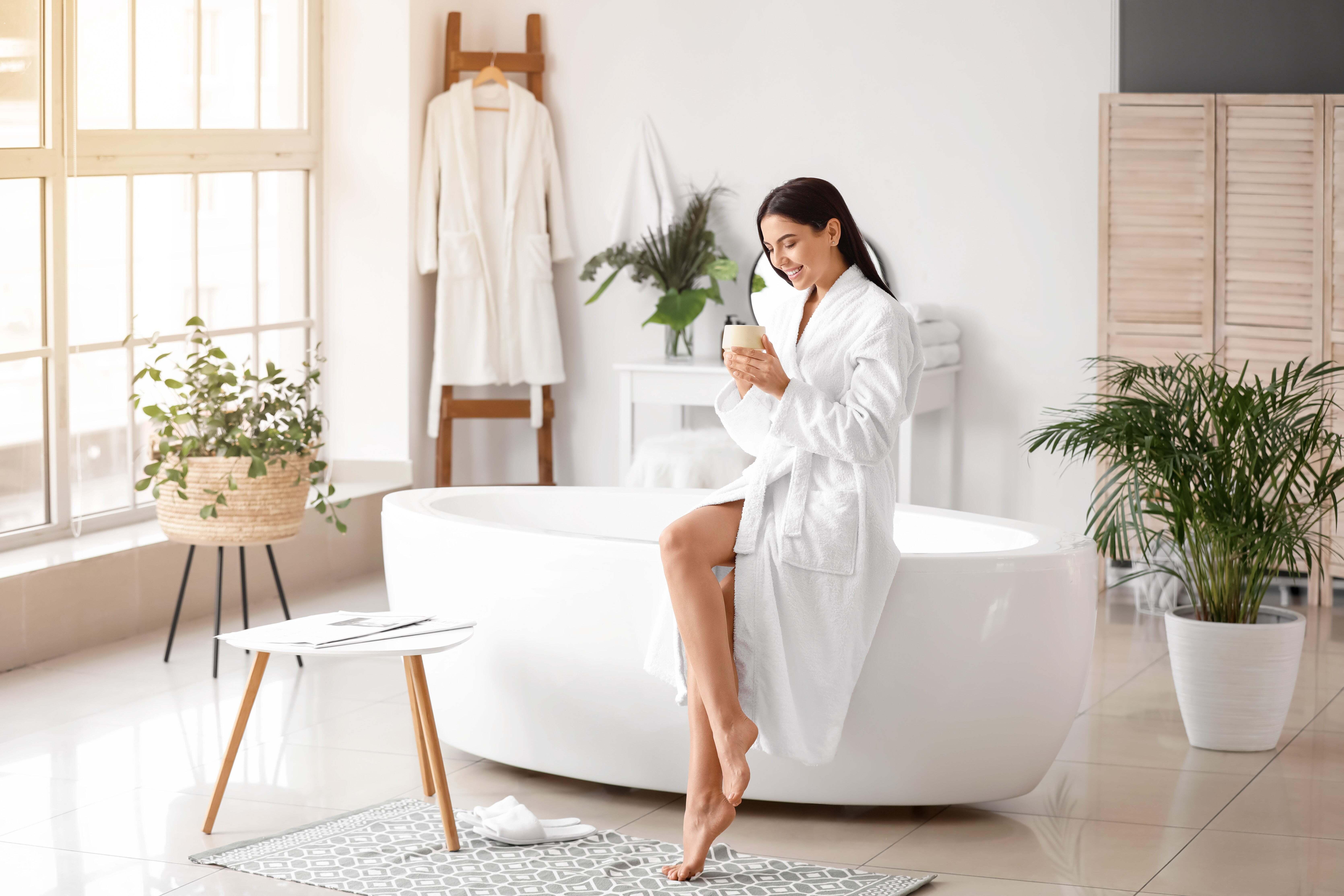A woman sitting on the edge of a bathtub