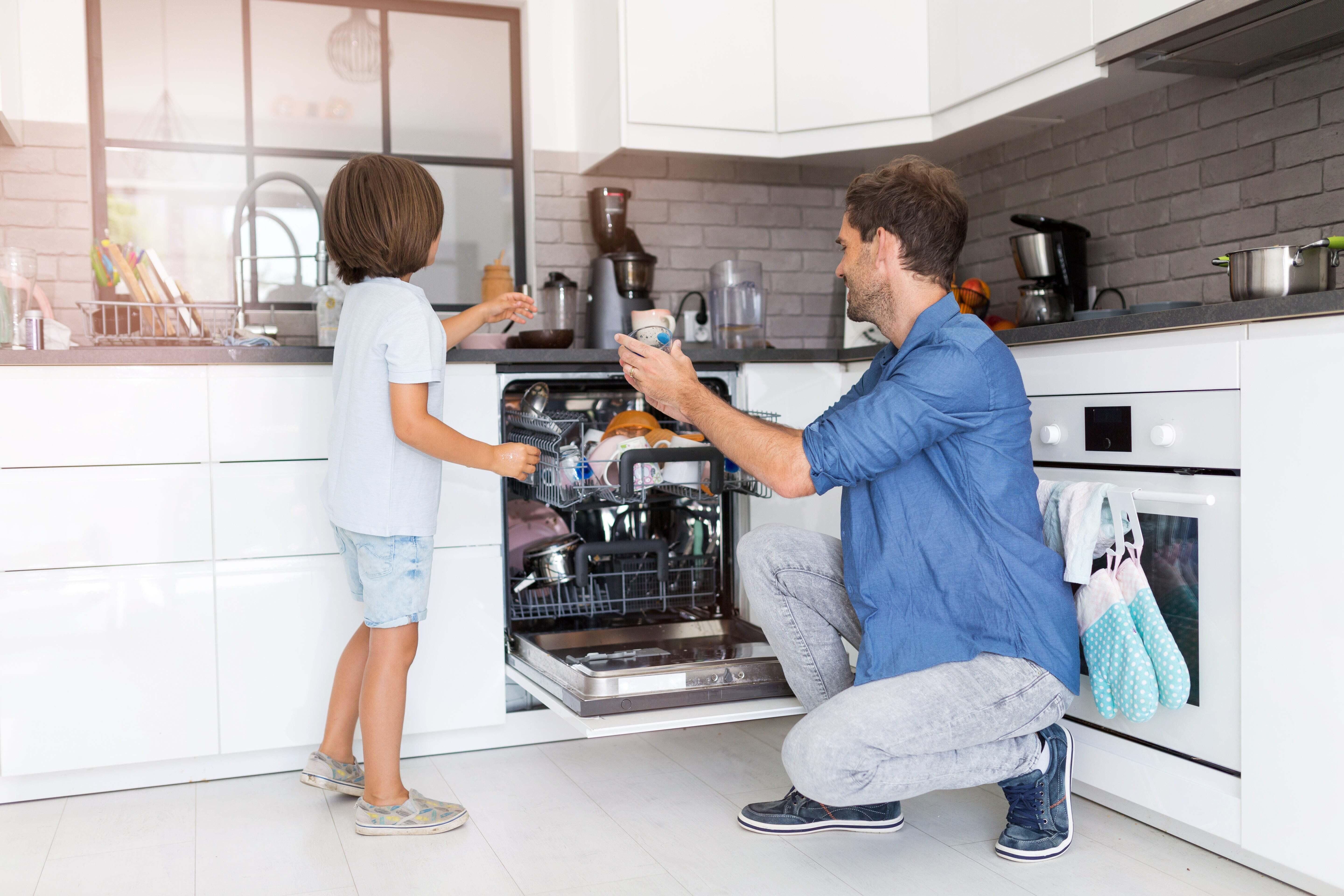 A father and a child loading the dishwasher