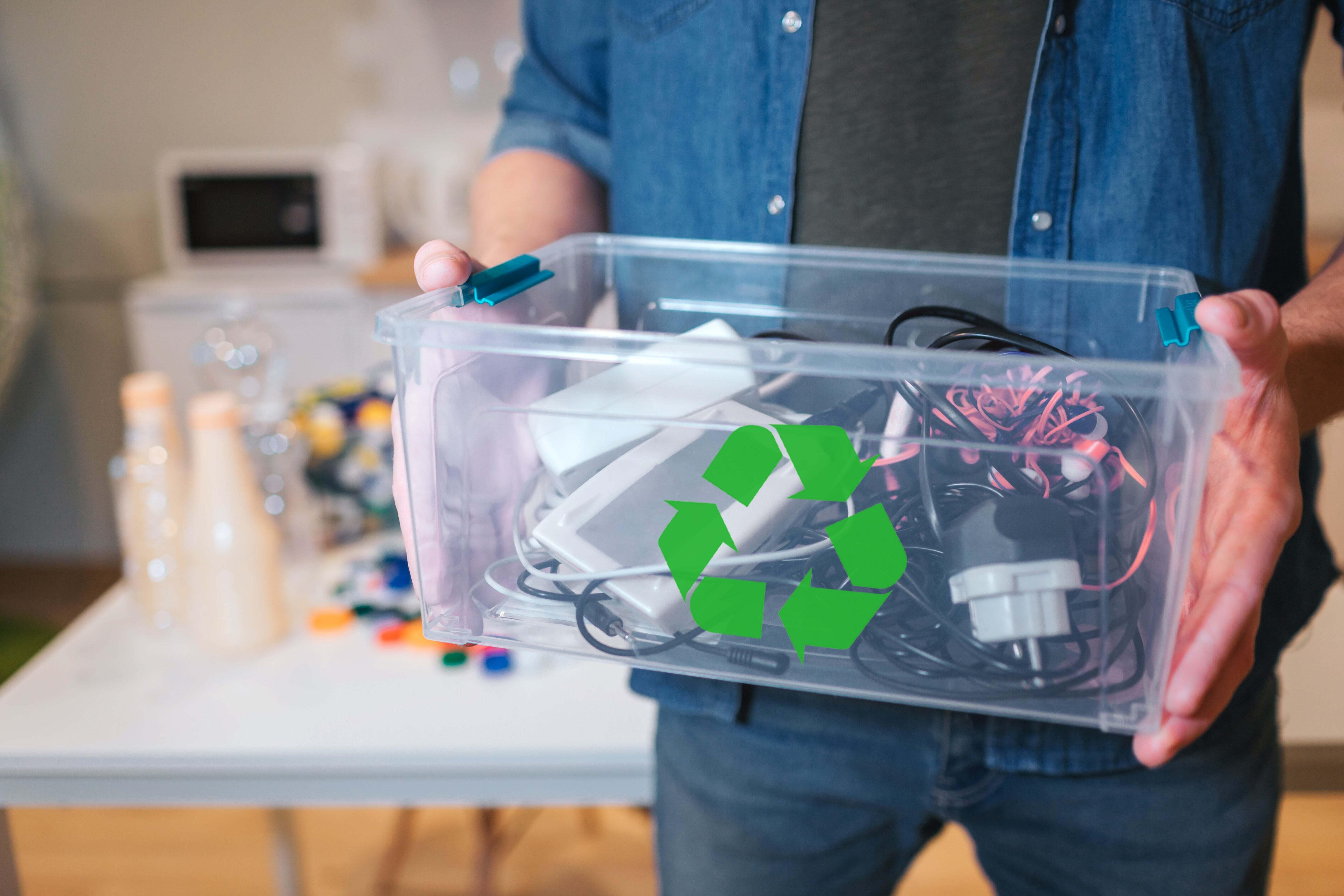 A man holding a container full of cords and wires