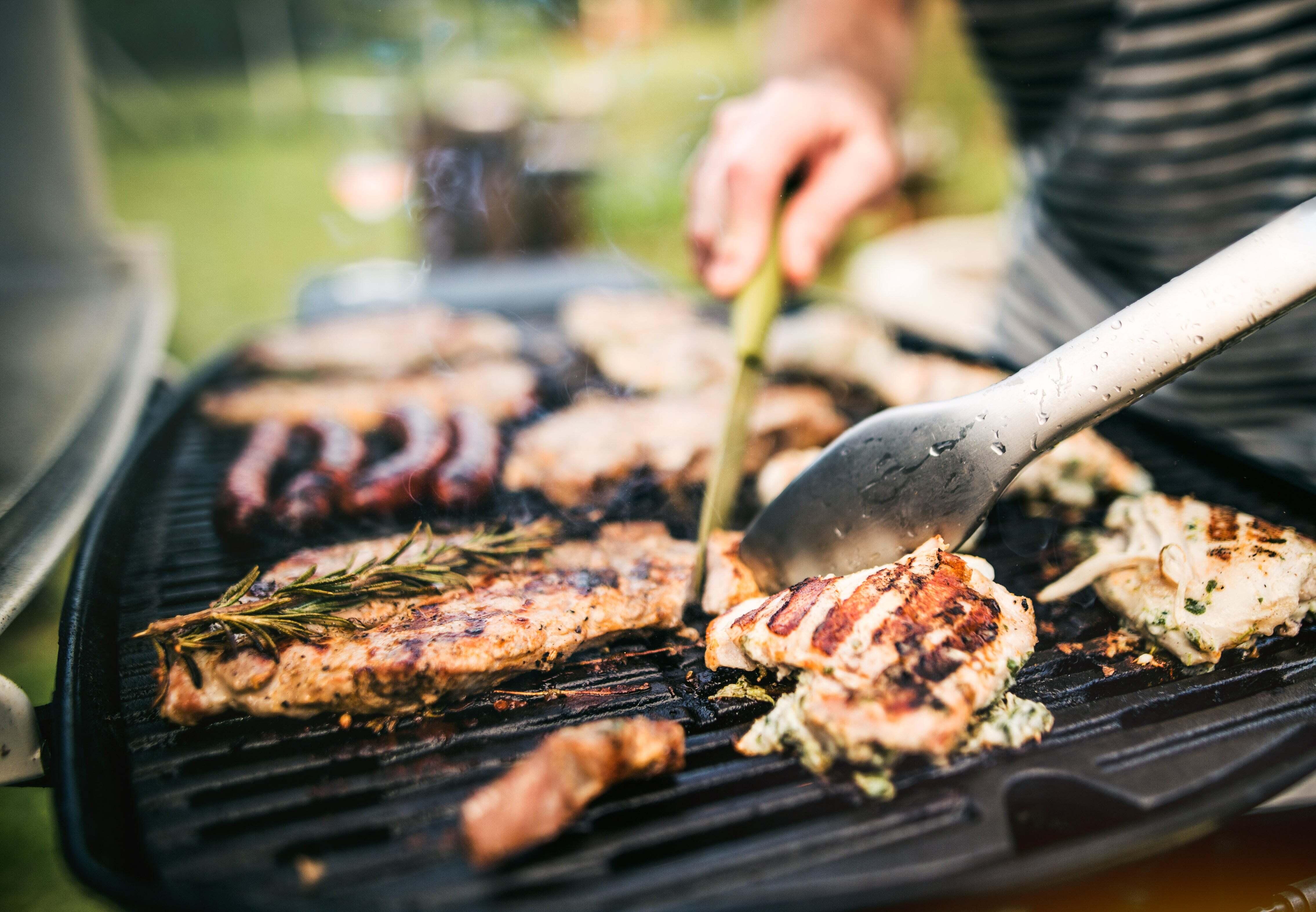 A man grilling chicken on an electric grill
