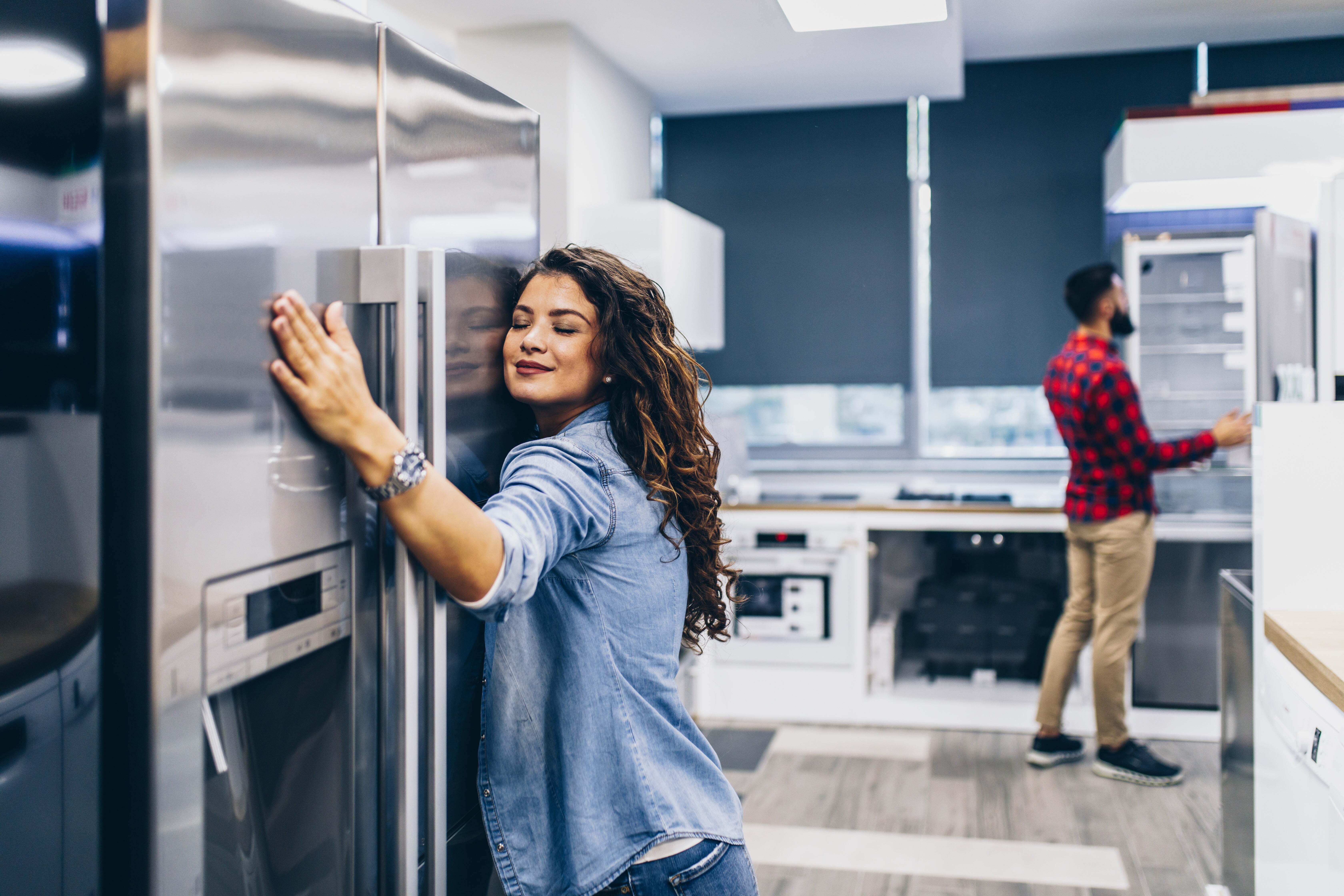 A woman hugging a refrigerator