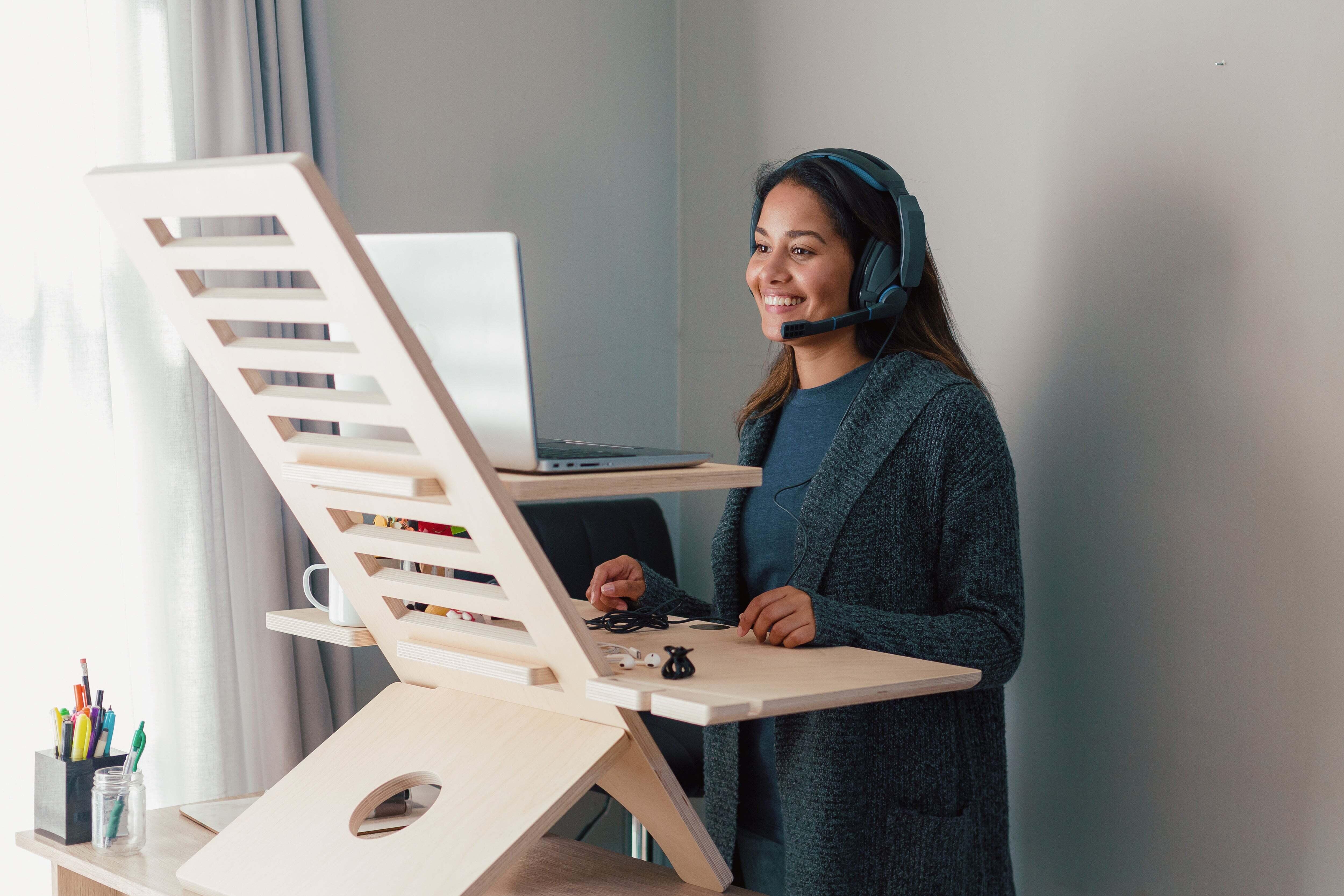 A woman smiling while working at a standing desk
