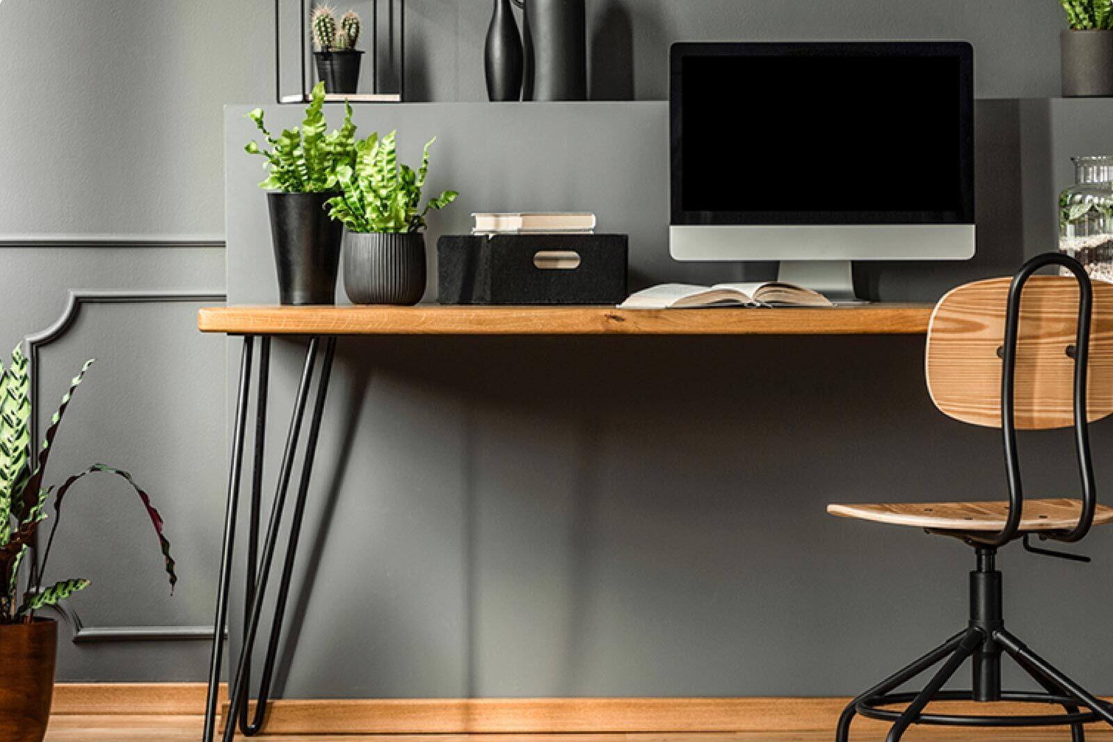 A comfortable desk set-up with a desktop computer is against a wall.